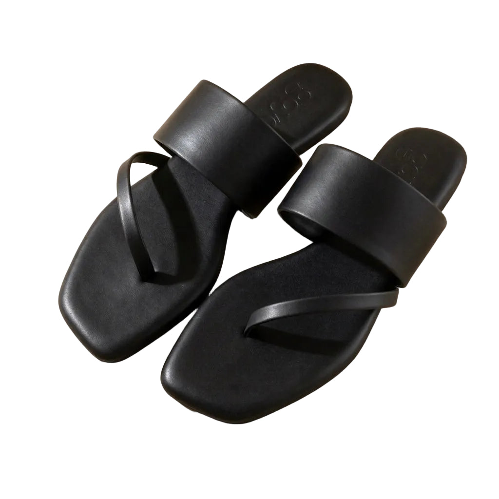 Pair of black sandals on a beige background